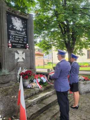 policjanci pod pomnikiem poległych i pomordowanych przez OUN- UPA