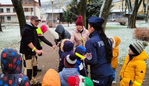 policjanci i dzieci rozdają odblaski przechodniom