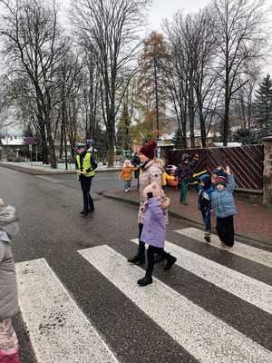 policjanci i dzieci rozdają odblaski przechodniom