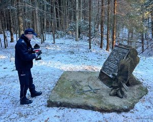 policjanci palą znicz w miejscu katastrofy