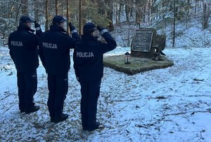 policjanci palą znicz w miejscu katastrofy