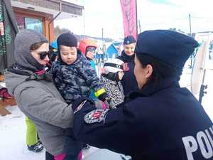 policjanci rozmawiają z narciarzami o ich bezpieczeństwie na stoku