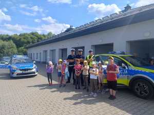 dzieci- uczestnicy letnich półkolonii odwiedzają policjantów w ich miejscu pracy