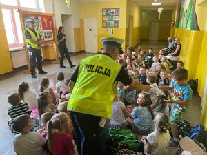 policjanci edukują dzieci, jak bezpiecznie poruszać się w pobliżu dróg