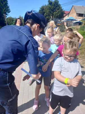 policjanci edukują dzieci, jak bezpiecznie poruszać się w pobliżu dróg