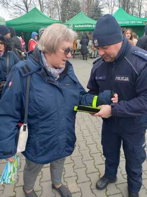 policjanci rozdają odblaski na jarmarku bożonarodzeniowym