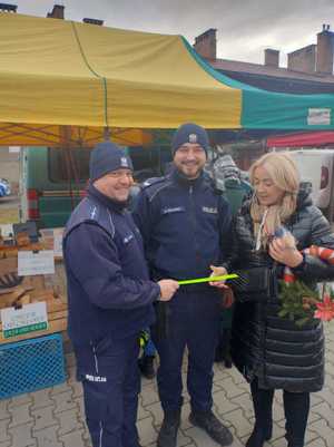 policjanci rozdają odblaski na jarmarku bożonarodzeniowym