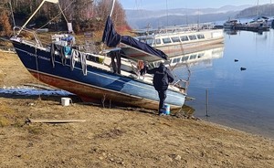 policjant sprawdza opuszczoną łódź na Jeziorem Solińskim, gdzie nocują osoby bezdomne