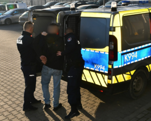 zatrzymany mężczyzna podczas konwoju do sądu