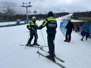 policjanci na nartach strzegą bezpieczeństwa na stoku narciarskim