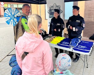 policjanci na policyjnym stoisku podczas biegu ulicznego promują pracę w Policji