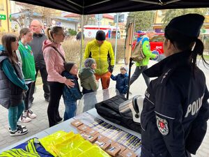 policjanci na policyjnym stoisku podczas biegu ulicznego promują pracę w Policji