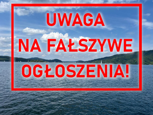 Widok na Jezioro Solińskie z napisem UWAGA NA FAŁSZYWE OGŁOSZENIA